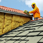 **

A cross-section of a Malaysian home roof showing mineral wool insulation (glass wool or rock wool) being installed. Highlight its fire resistance. Include a person wearing protective clothing. Show the tropical climate outside.

**
